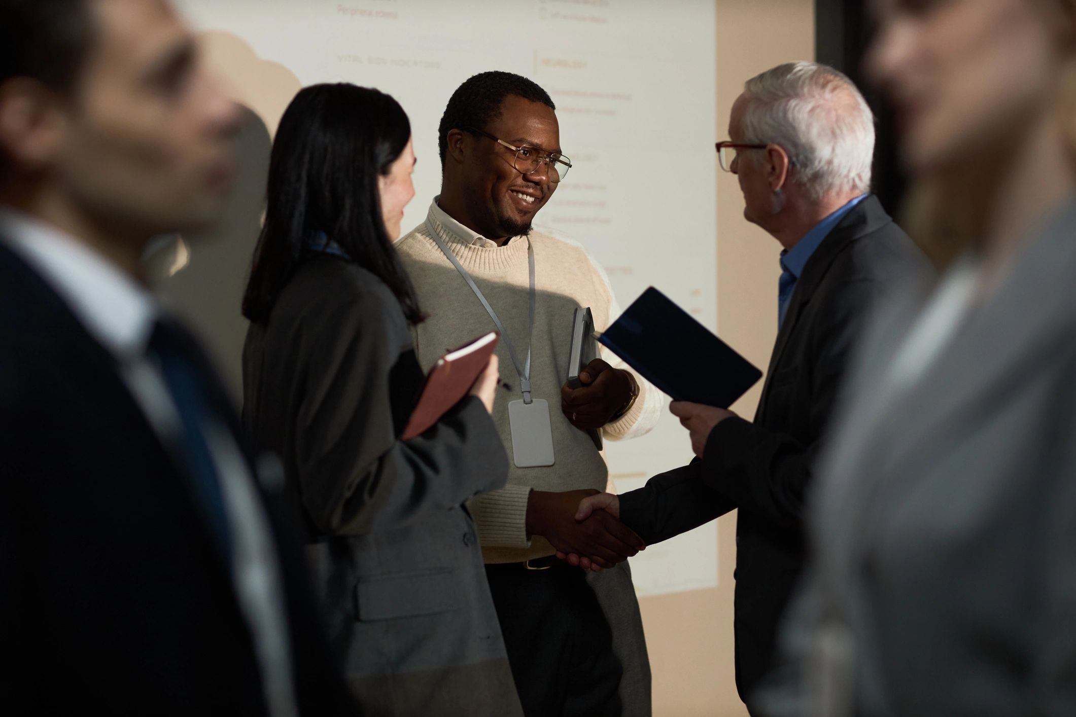 Two executives greeting each other during a professional leadership event